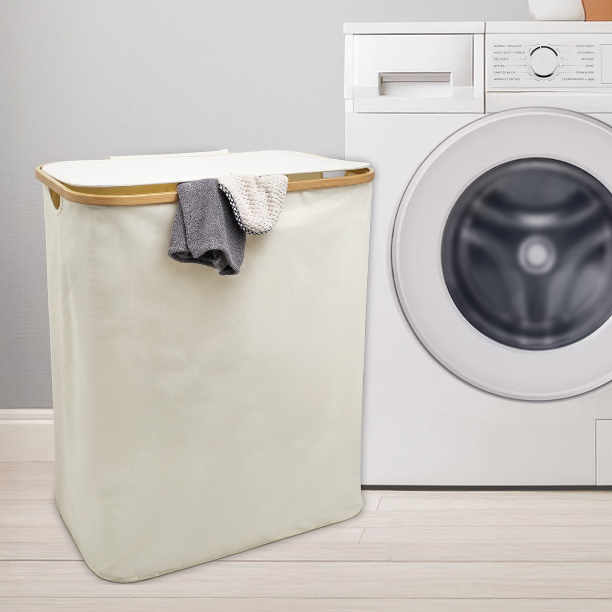 Cream double laundry hamper with lid beside washing machine