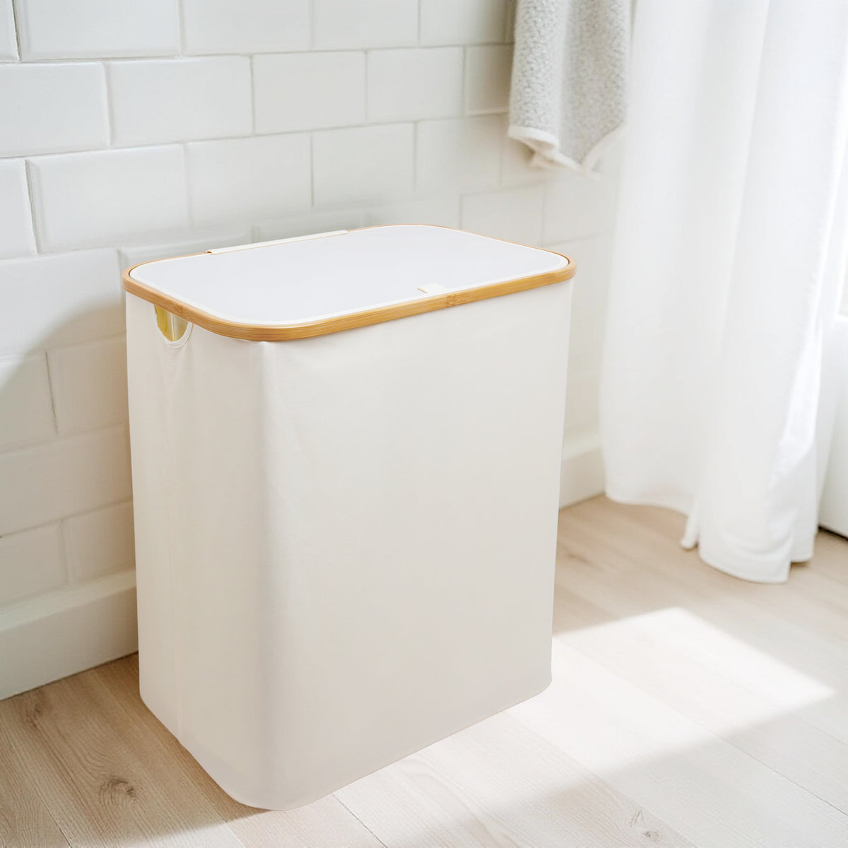 Cream double laundry hamper with lid beside washing machine