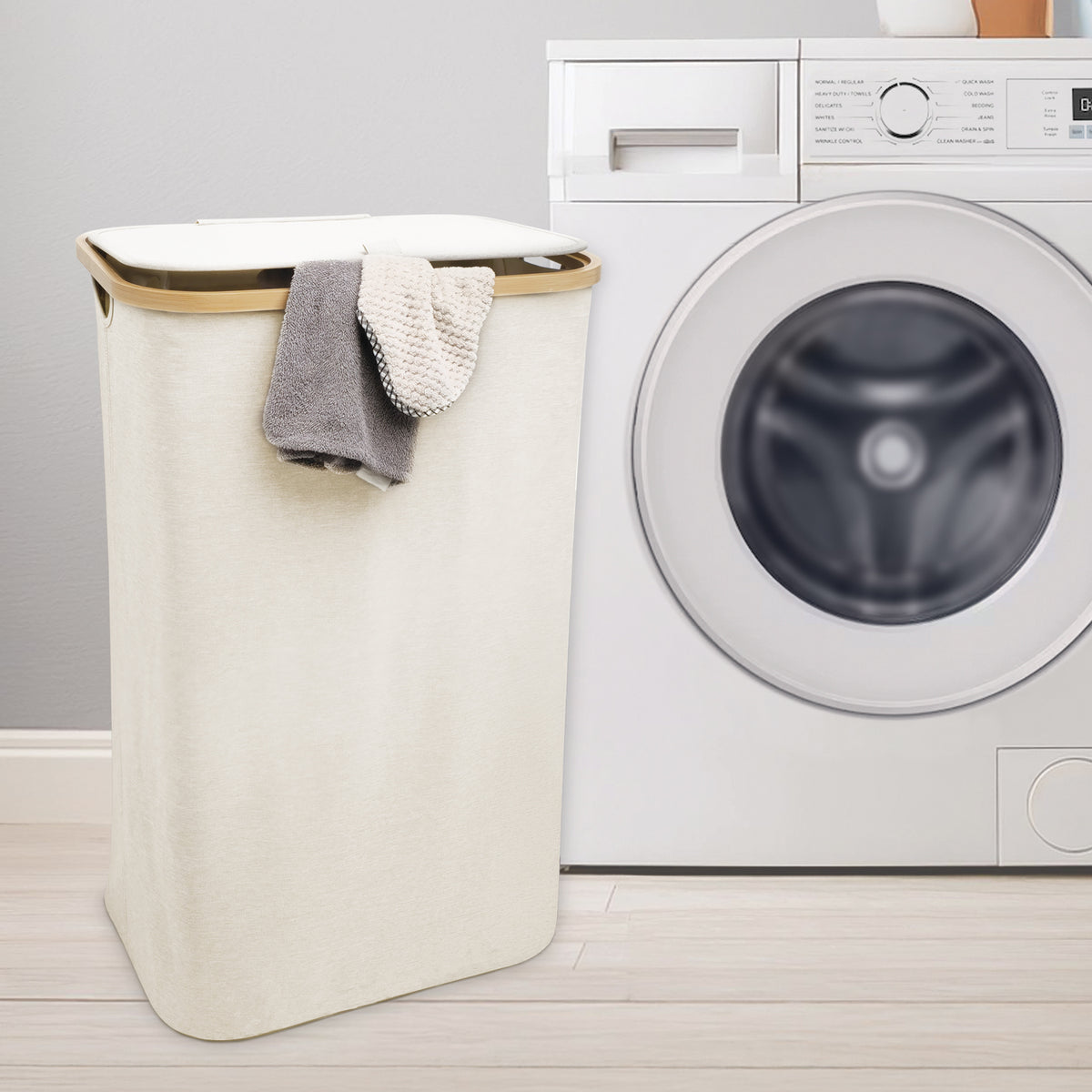 Cream laundry hamper with removable bag beside washing machine