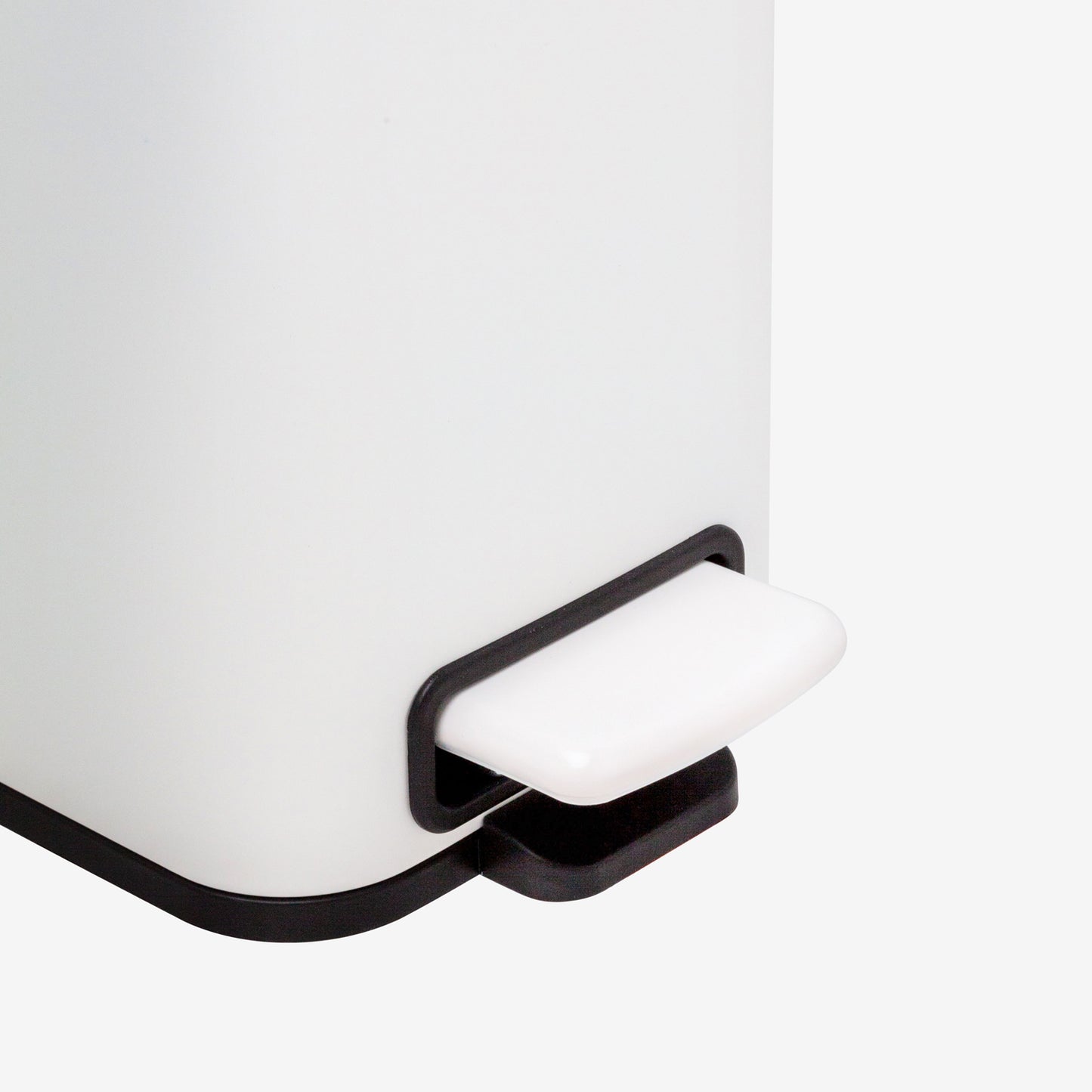 Hands-free foot pedal on small matte white trash can