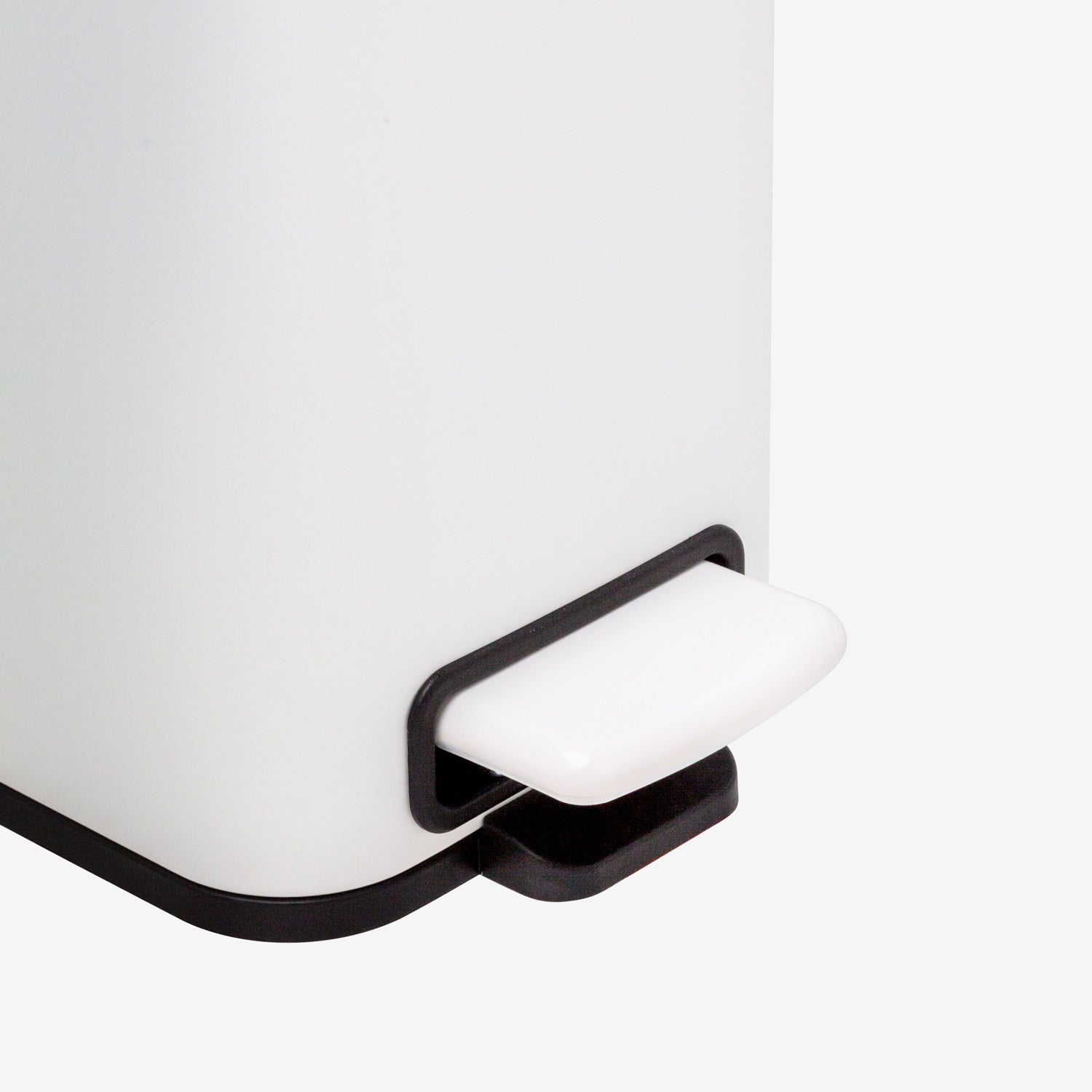 Hands-free foot pedal on small matte white trash can