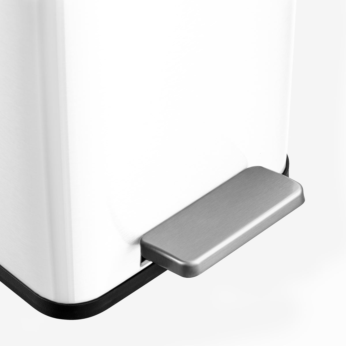 Hands-free stainless steel step pedal on white bathroom trash can