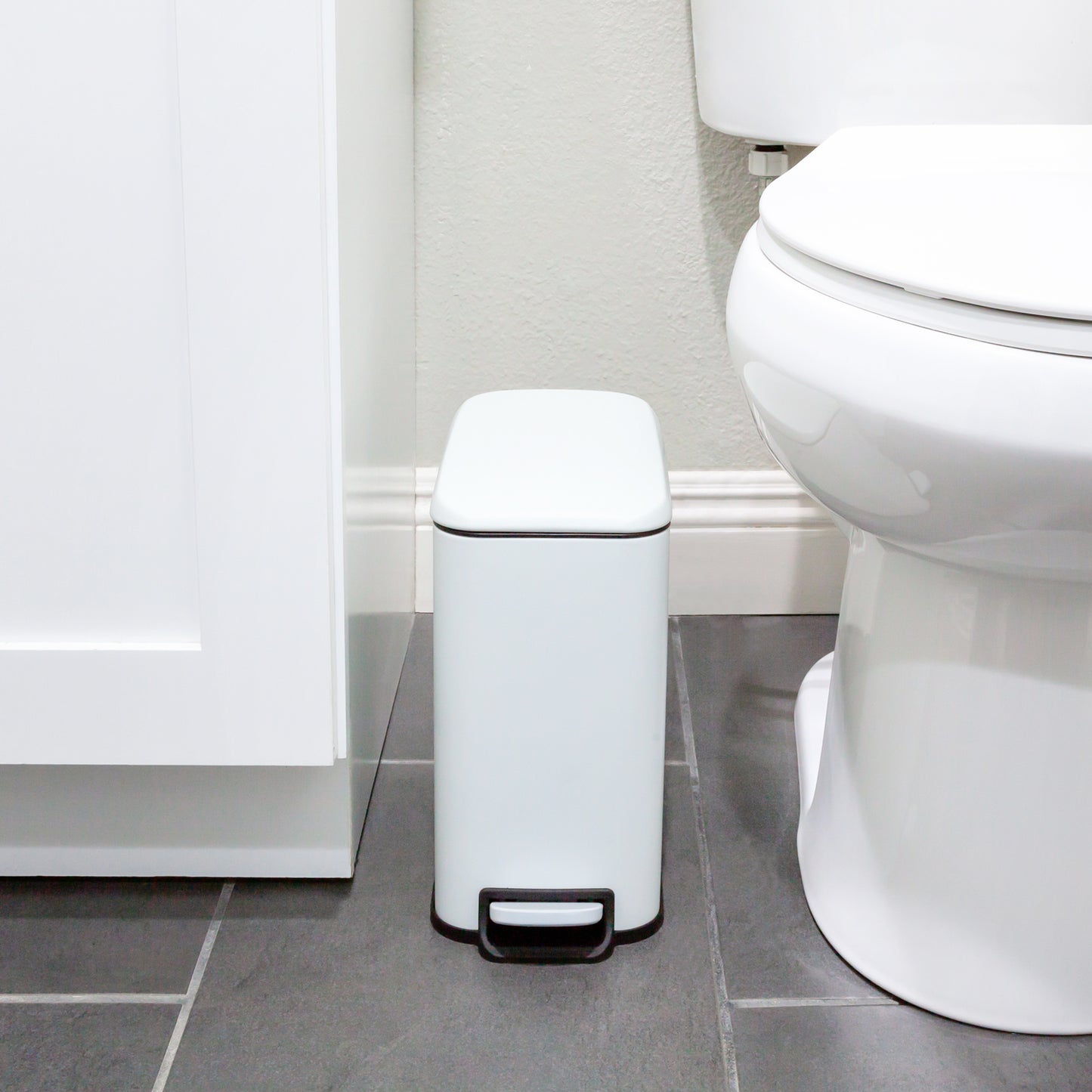 Narrow white trash can designed for small bathroom spaces