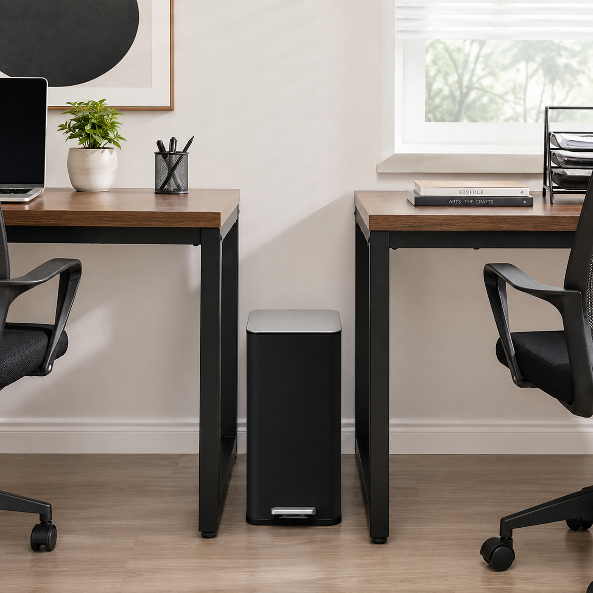 Slim black step trash can fitting beside furniture in a small space