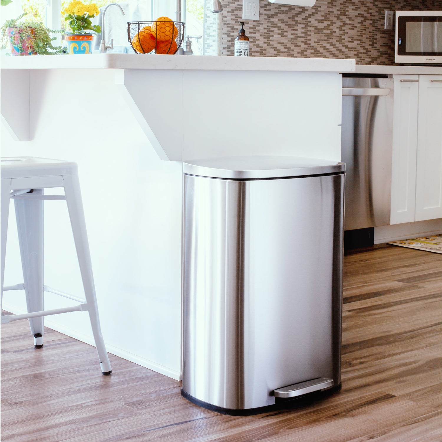 Stainless steel 13.2 gallon step trash can in a modern kitchen