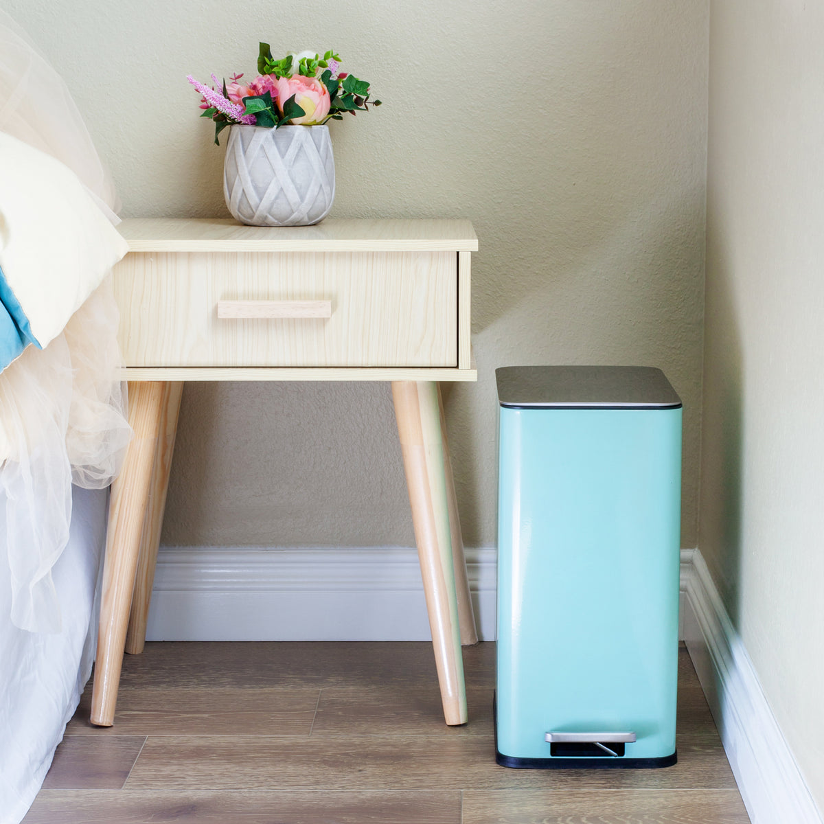 Baby blue slim trash can in a small bedroom